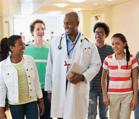 High school students standing with doctor