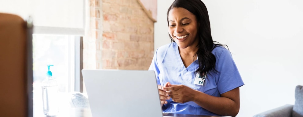 Nurse using laptop at home