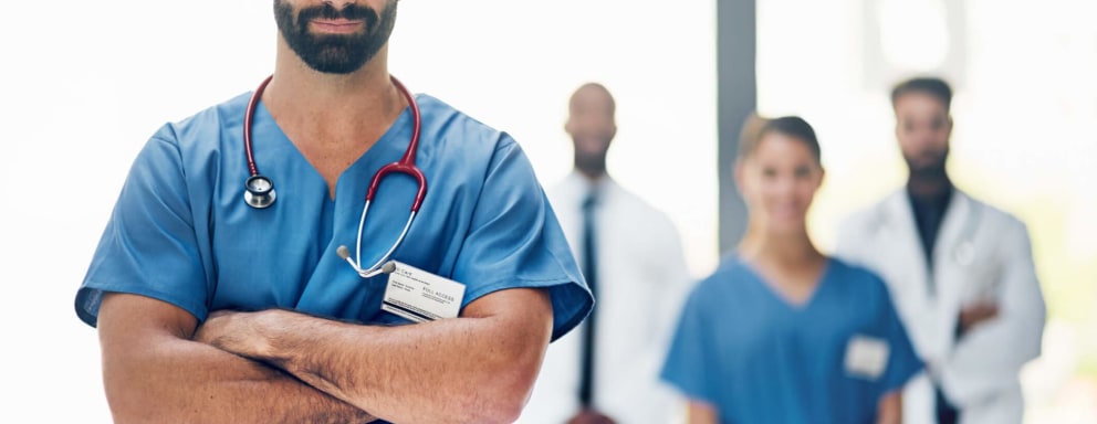 Confident male nurse standing in front of coworkers