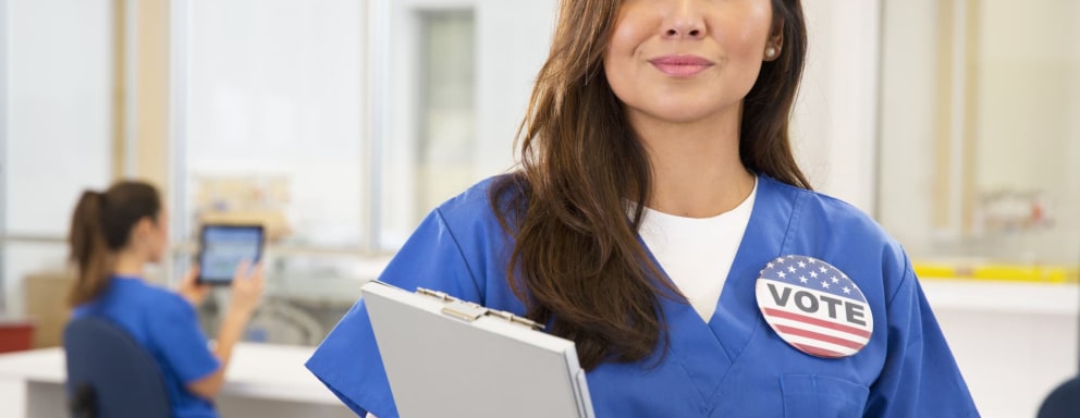 Nurse wearing Vote button in hospital