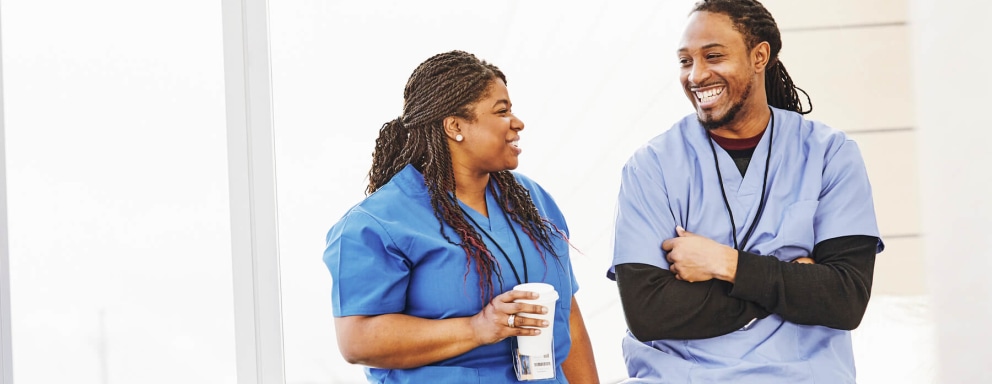 Male and female nurse talking in a hospital lounge