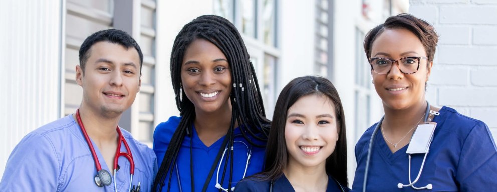 Diverse group of four nursing students standing together