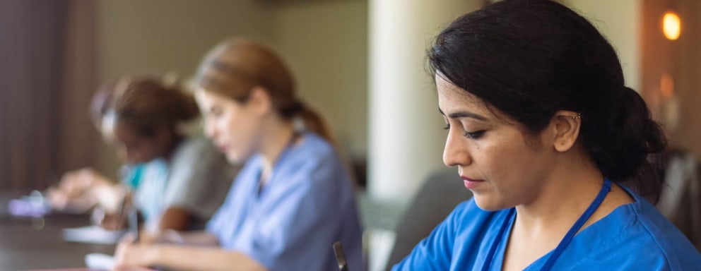 Nursing students taking notes at desks