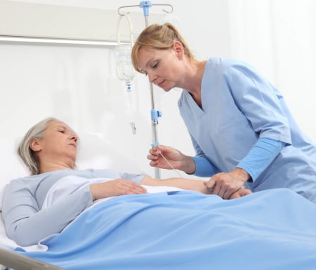 Nurse connecting IV to patient's arm