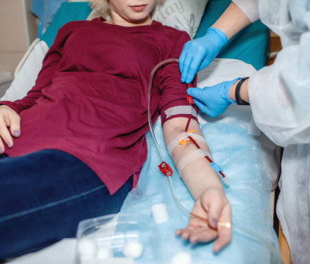 Patient hooked up to machines in a hospital getting help from a medical professional