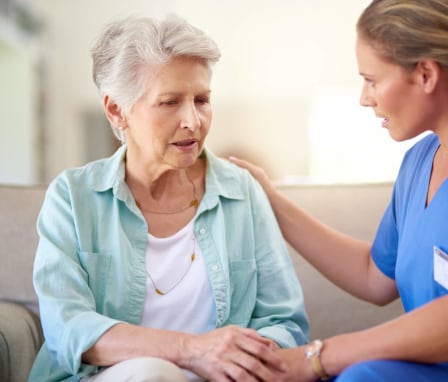 Nurse consoling senior patient