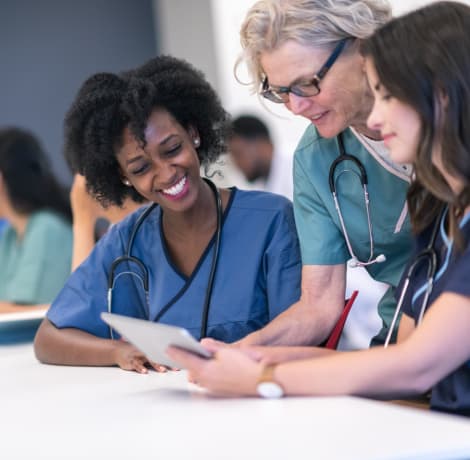 Older nurse helping nurses in class