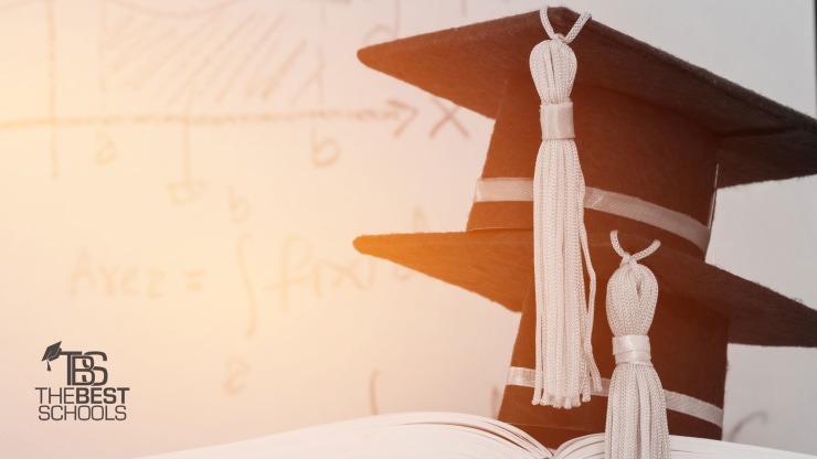 two graduate caps sitting on a book