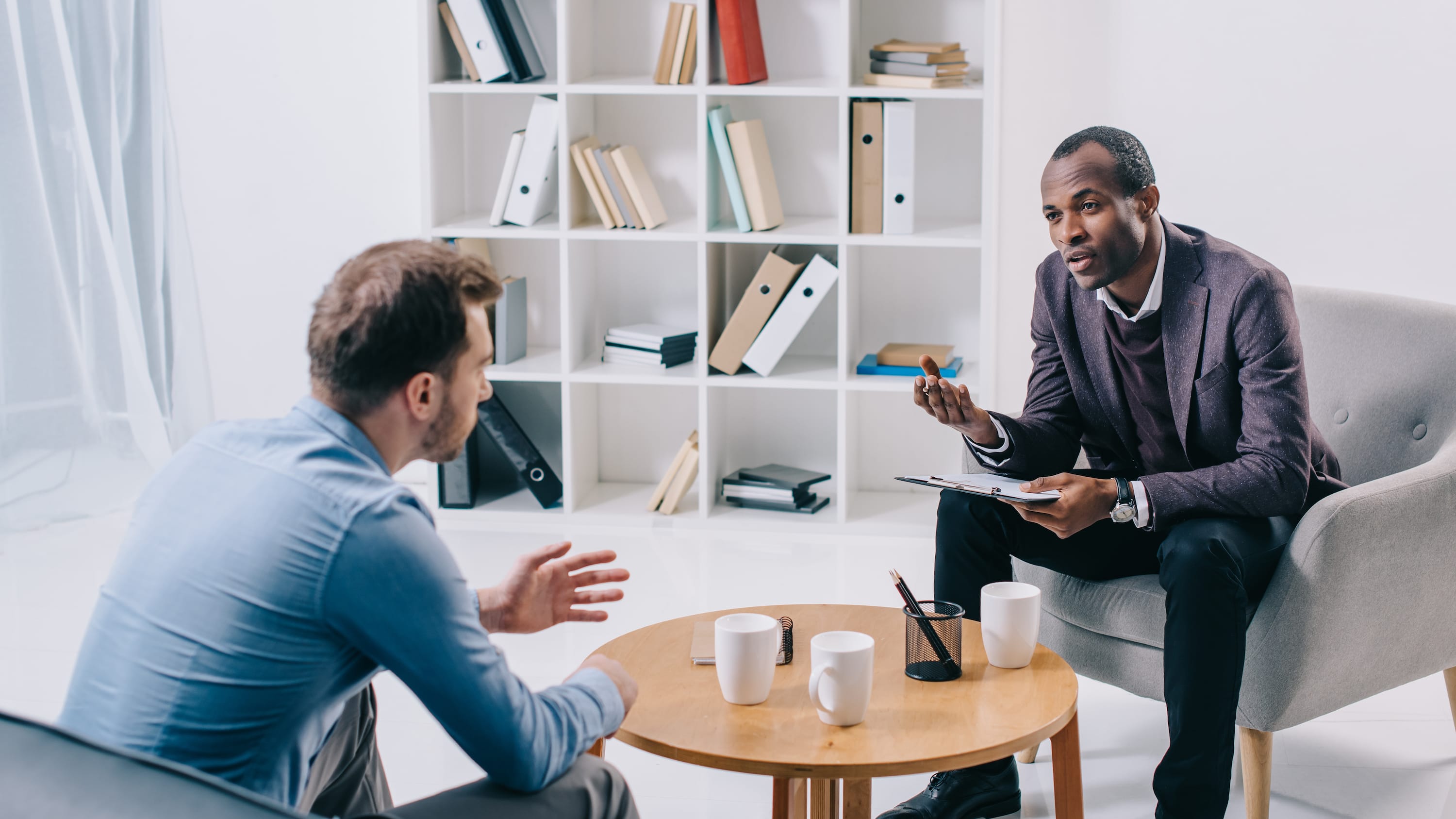 Most Affordable Online Bachelor’s in Psychology Degree Programs hero image, male therapist with patient in office