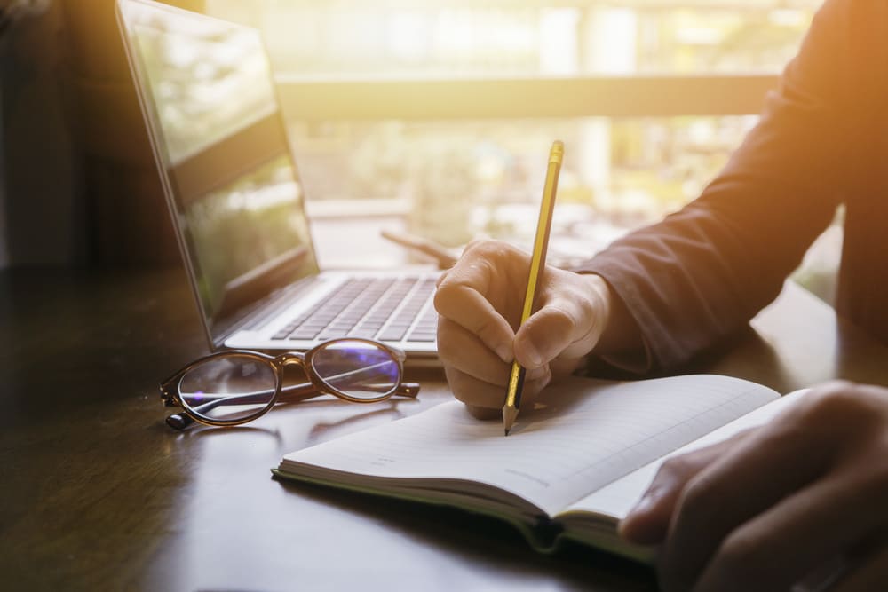 A picture of someone writing in a notebook.