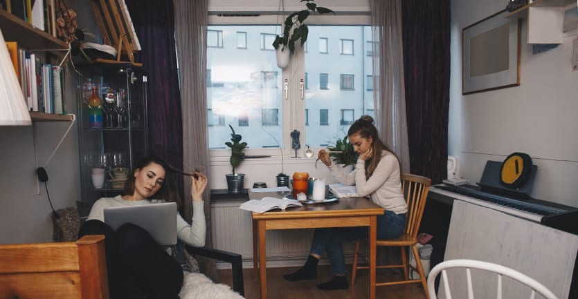 Two young women study and lounge in their chicly designed urban dorm room.