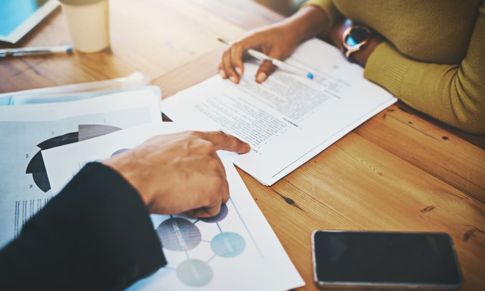 Above angle image of an employer and potential employee during an interview with resume.