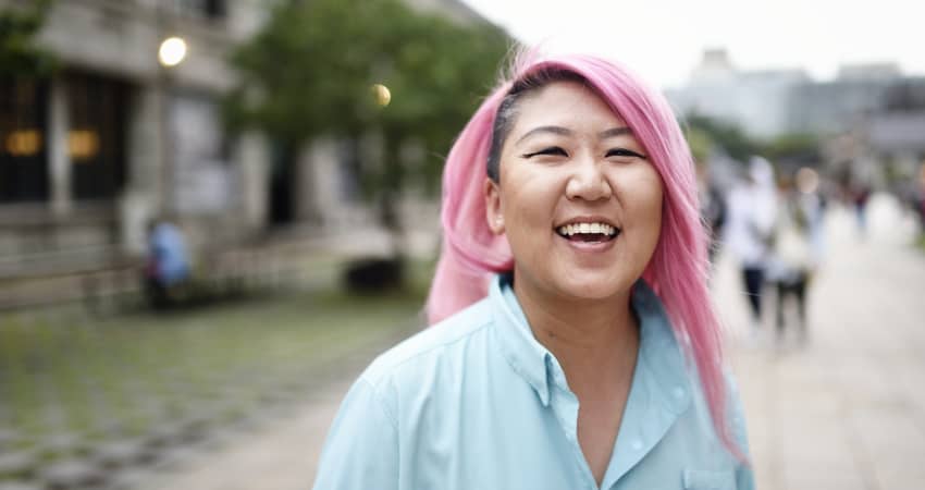 A pink-haired student smiles