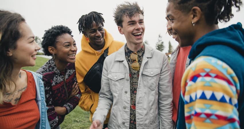 Several students on a playfield talk and laugh