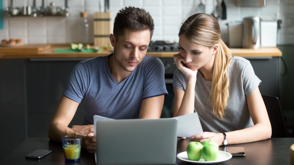 couple in kitchen on laptop looking for student loans
