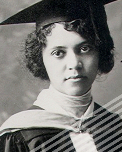 A short-haired Alice Ball in graduation cap and gown looks slightly askance in a black-and-white photograph.