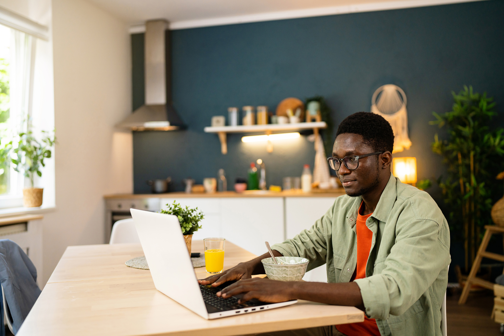 online student in kitchen on laptop