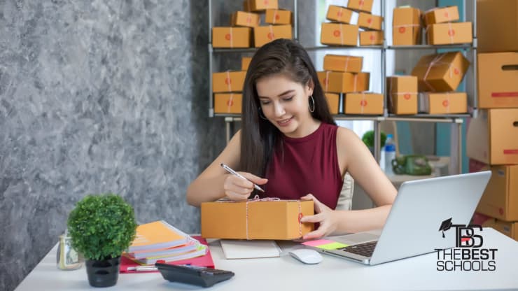 The 10 Best Online Bachelor's in Entrepreneurship Programs Hero Image: The 10 Best Online Bachelor's in Entrepreneurship Programs (Image of a woman entrepreneur marking packages to ship from her business)