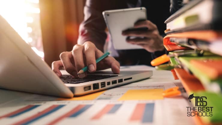 The Best Online Bachelor's in Internet Marketing Programs Hero Image: Best Online Bachelor's in Internet Marketing Programs (image of a man, in closeup, holding a tablet device on one hand and typing onto a keyboard attached to a desktop with the other.)