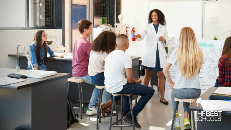 The Best Online Master's in Science Education Programs Hero Image: Best Online Master's in Science Education Programs (image of a strapping science educator calling upon an eager student in a laboratory-style classroom setting)