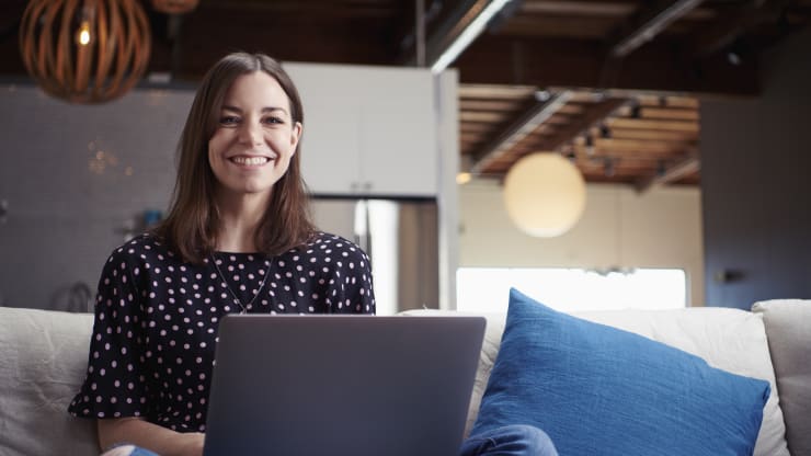 The Most Affordable Online Bachelor's in English Degree Programs Hero Image: The Most Affordable Online Bachelor's in English Degree Programs (A writer or editor smiling at the camera while working on their laptop)