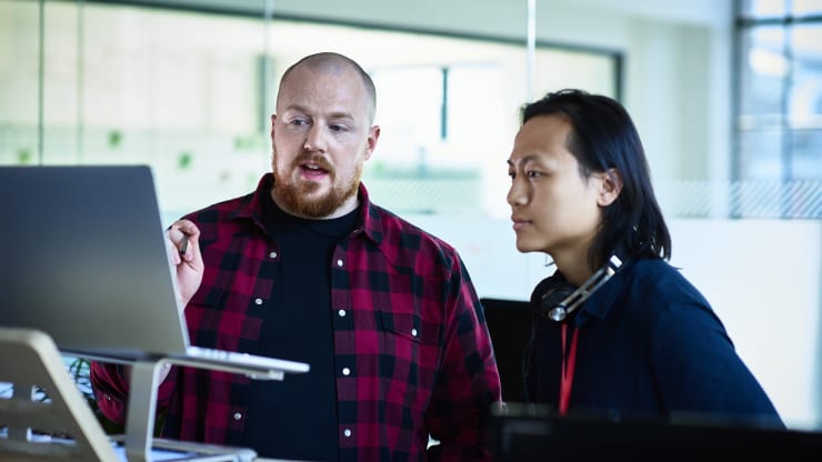 The Most Affordable Online Master's in Information Technology Degree Programs Hero Image: The Most Affordable Online Master's in Information Technology Degree Programs (Image of two IT professionals looking over a laptop)