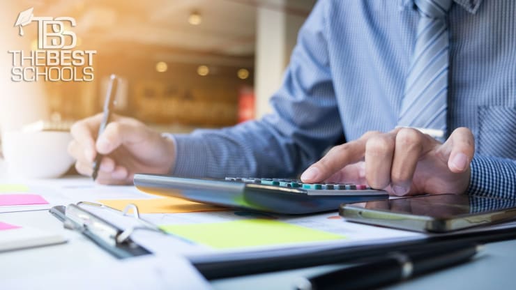 Hero Image for What Can I Do With an Accounting Degree: Image of man at desk writing and using a calculator