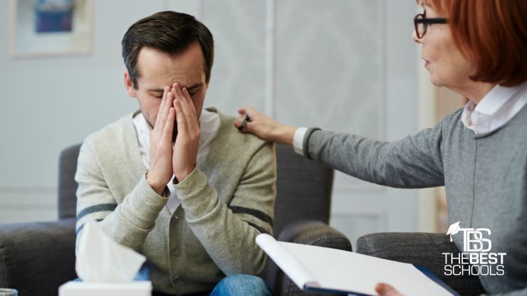 Best Online Bachelor’s in Behavioral Psychology Programs Hero: Sad man with hands folded being comforted by female therapist