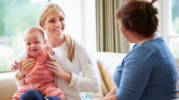 Most Affordable Online Bachelor’s in Social Work Degree Programs hero image, woman with baby smiling at social worker
