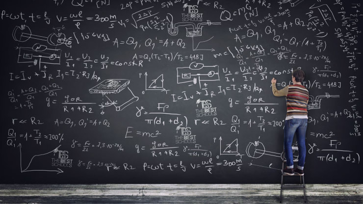 Hero image for What Can You Do With a Math Degree?: Man on stool writing on enormous chalkboard filled with mathematical equations
