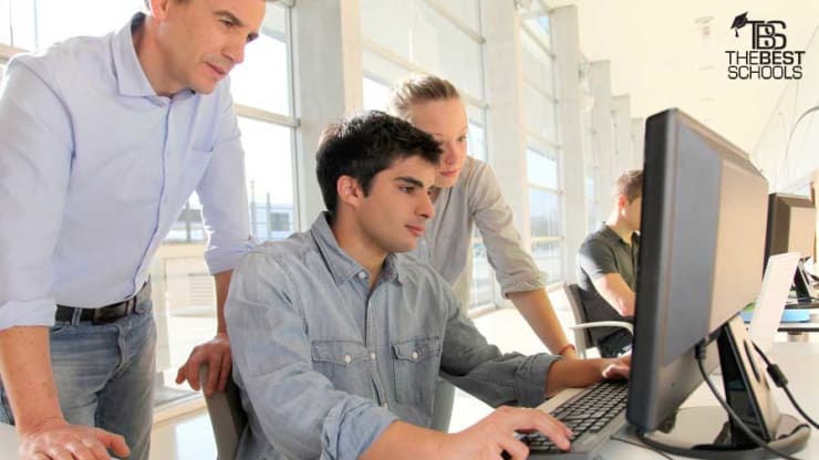 Best Online Management Informations Systems Degree Programs Hero: Image of three young white men looking at a computer screen.