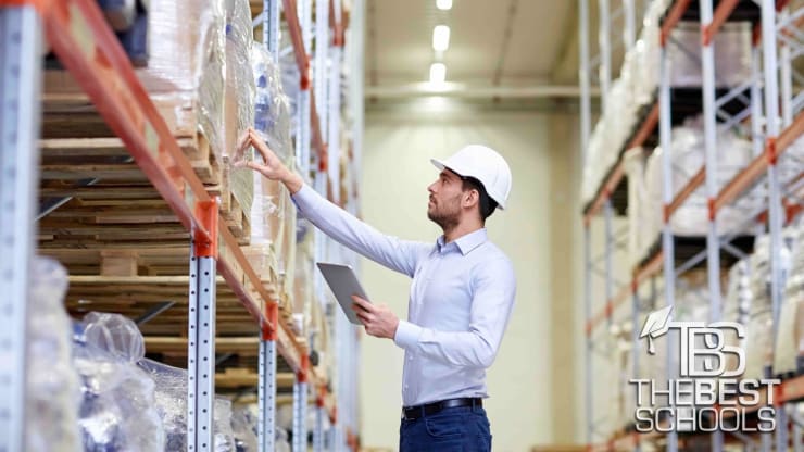 Man in hardhat examining item on warehouse shelf