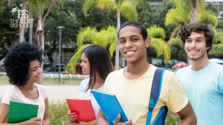 Egyptian male student with other international students outdoors on campus of university in summer