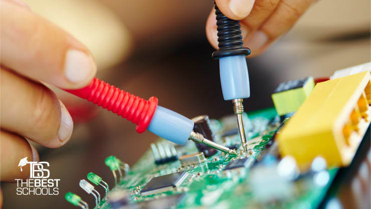 Close up shot of white person’s hands working on a circuit