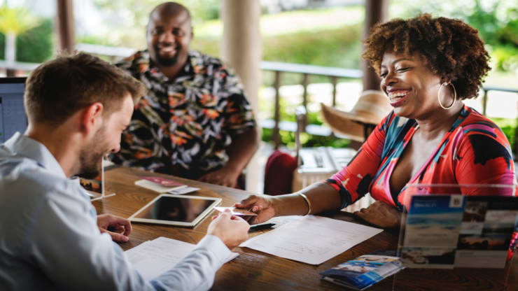 Black woman and man checking into a resort hotel.