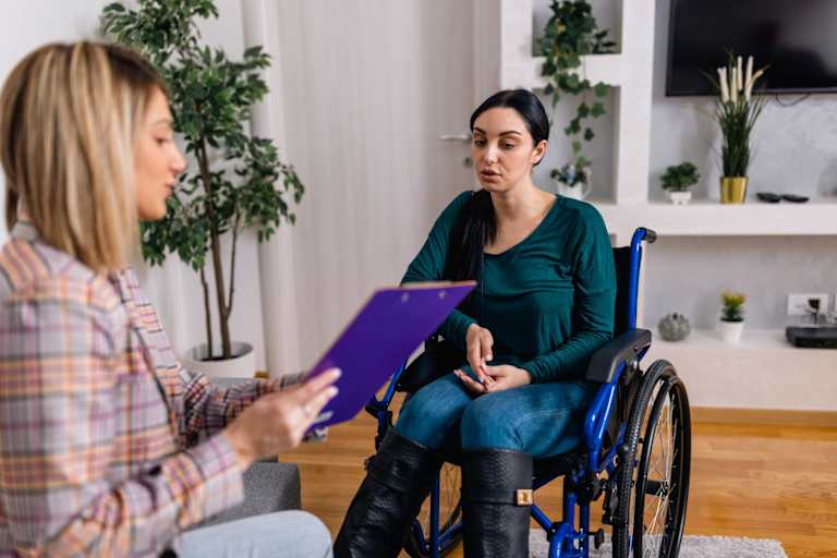 Rehabilitation counselor speaking to patient in wheelchair