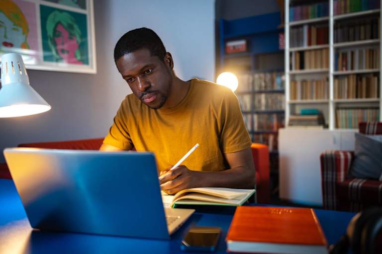 College student studying on laptop at home