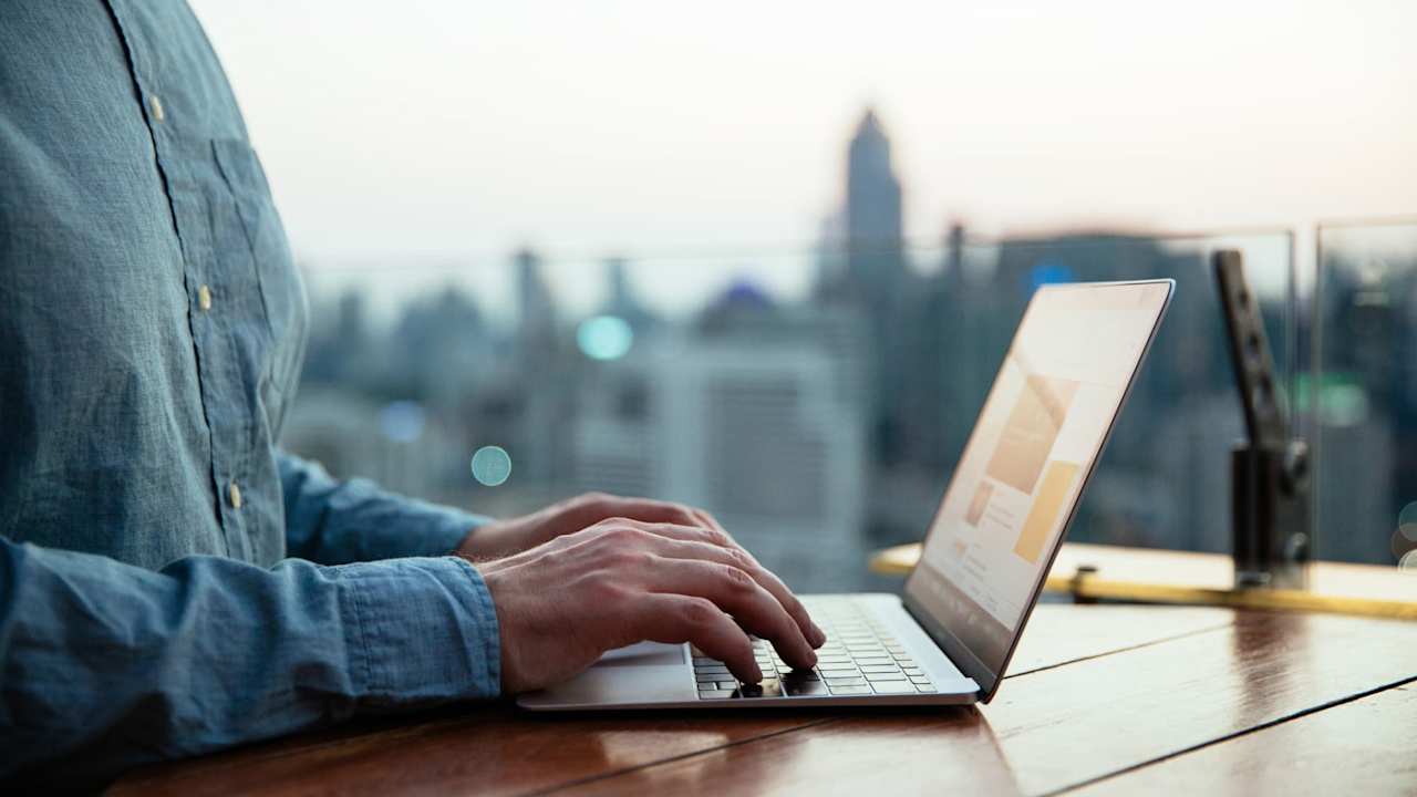 Hands typing on laptop