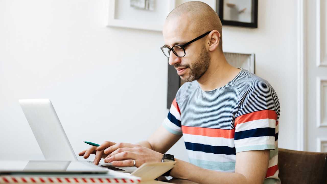 Man sitting in a comfortable office and working on a laptop