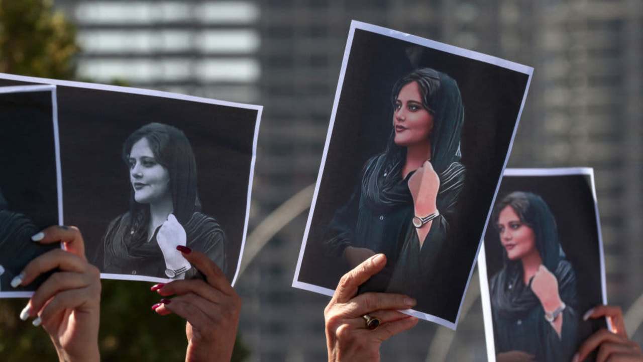 Women hold up signs depicting the image of Mahsa Amini, who died while in the custody of Iranian authorities, during a demonstration denouncing her death by Iraqi and Iranian Kurds outside the UN offices in Arbil, the capital of Iraq's autonomous Kurdistan region, on September 24, 2022.