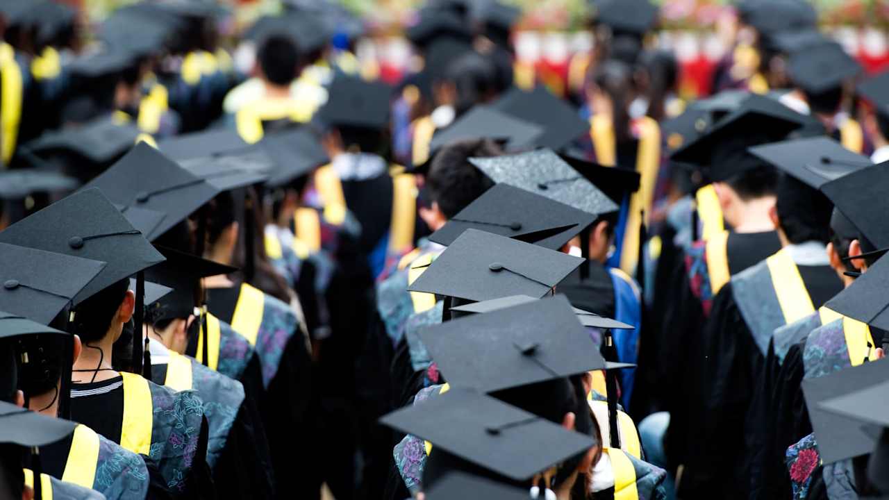 Group of college students wearing graduation caps and gowns at their commencement ceremony.