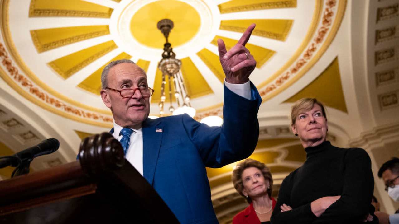 Senate Majority Leader Chuck Schumer speaking to reporters after a policy meeting with Senate Democrats at the U.S. Capitol in Washington, DC. Also pictured in the background are Senators Debbie Stabenow and Tammy Baldwin.