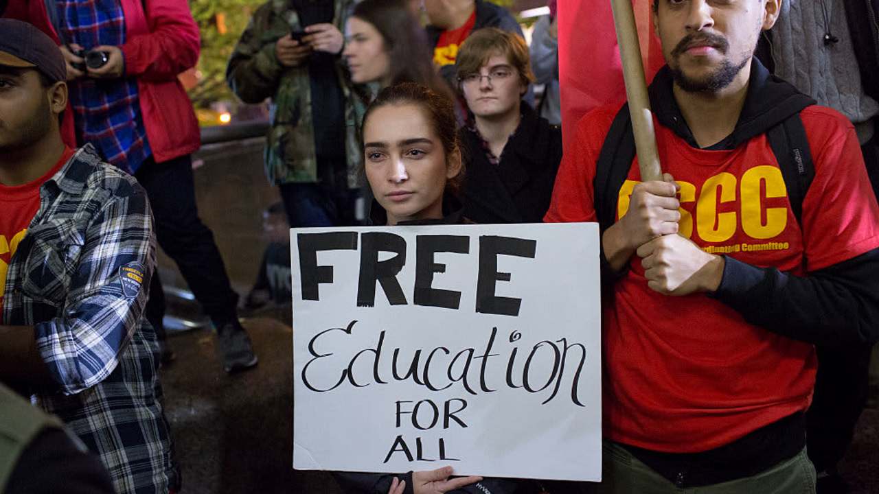 College students protesting, holding sign that reads "Free education for all"