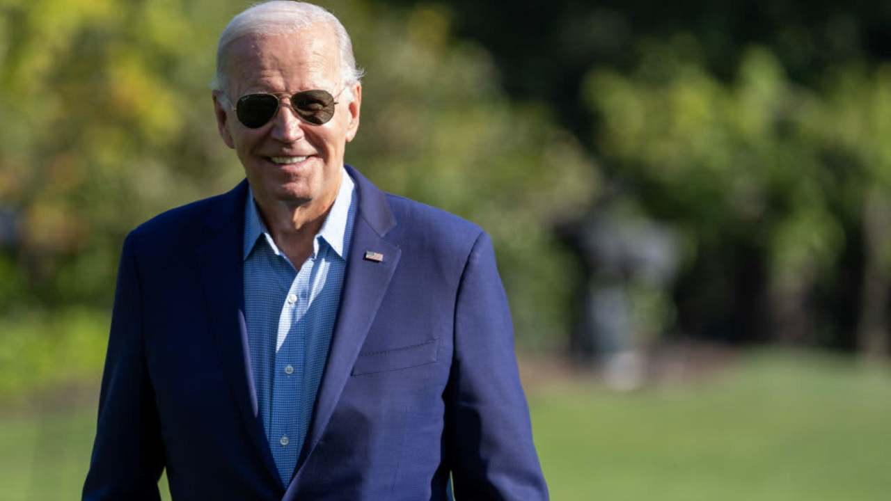 President Joe Biden walking outside and smiling