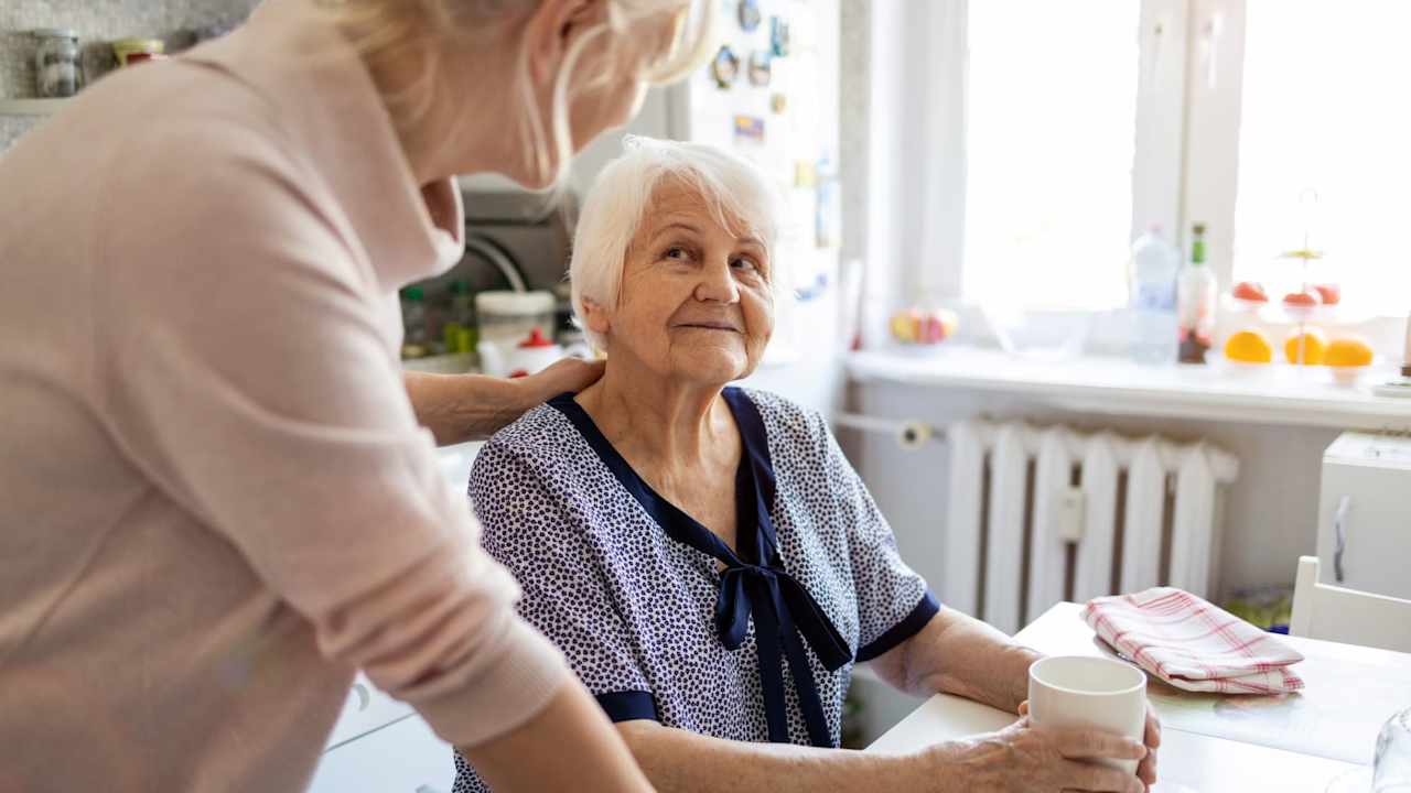 Adult daughter caring for her elderly mother with dementia