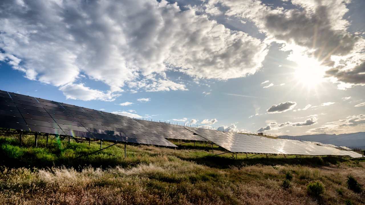 A beautiful blue sky and cloudscape around sunset at a solar farm in Western Colorado.