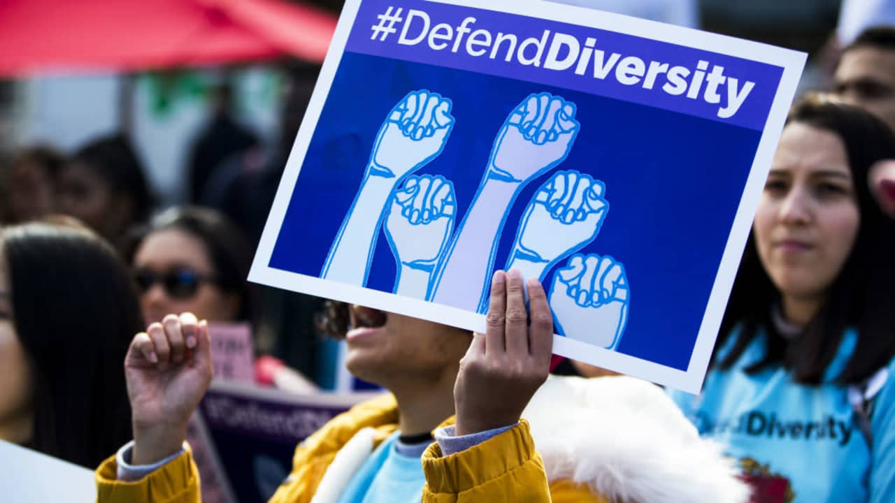 A demonstrator supporting Harvard University's admission process holds a sign that reads "Defend Diversity" during a protest