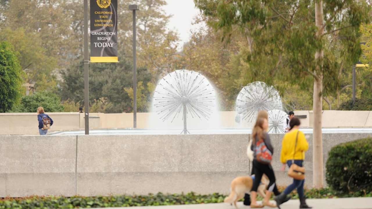 Students walking near the water fountain on the campus of California State University Long Beach.