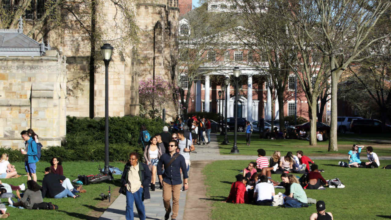 Students walking to class on a sunny spring day near Sterling Library on the Yale University campus.