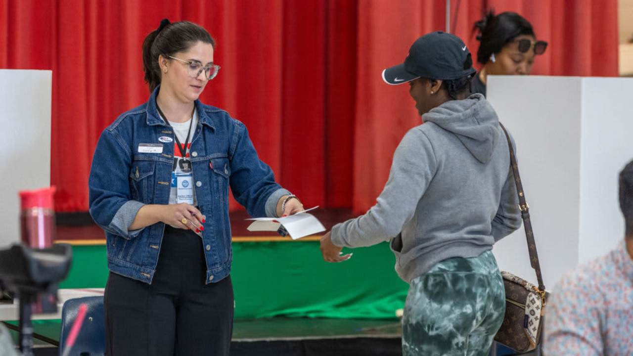 Poll workers assist a voter on Super Tuesday at the First Ward Creative Academy on March 5, 2024 in Charlotte, North Carolina.